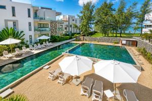an image of a swimming pool with chairs and umbrellas at PARATY Apartment l Complex Ocean Terraces in Poste Lafayette +39 photos