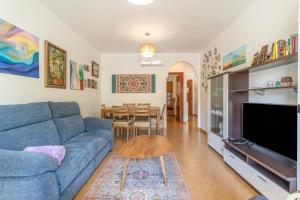 a living room with a blue couch and a table at Apartment Mountain View Torrox town in Torrox