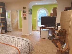 a bedroom with a bed and a flat screen tv at La Pastorale in Nyons