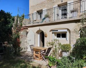 a wooden table and chairs in front of a building at La Pastorale in Nyons