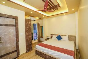 a bedroom with a bed and a ceiling fan at Hotel Sea Wood in Digha +22 photos