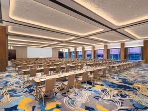 a large room with rows of tables and chairs at Mövenpick Resort & Spa Bintan Lagoon in Lagoi +107 photos