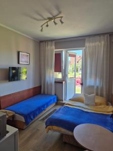 a bedroom with two beds and a tv and a table at Dom pod lipą in Łeba