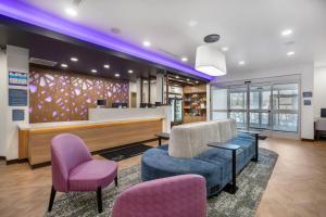 a lobby with chairs and a reception desk with purple lighting at Sleep Inn & Suites Henderson - Las Vegas in Henderson +31 photos