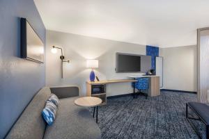 a living room with a couch and a desk in a hotel room at Sleep Inn & Suites Henderson - Las Vegas in Henderson