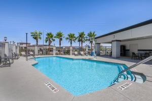 a swimming pool at a resort with chairs and palm trees at Sleep Inn & Suites Henderson - Las Vegas in Henderson