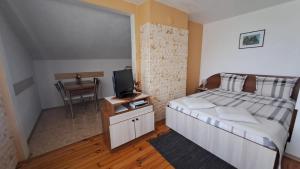 a bedroom with a bed with a television and a table at Geto Apartment in Belogradchik