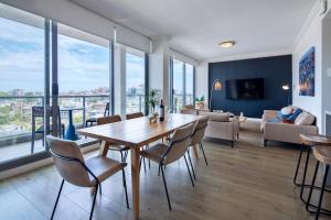 a dining room with a table and chairs and a living room at Zara Tower – Luxury Suites and Apartments in Sydney