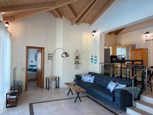 a living room with a blue couch and a table at Villa QuintaBella in Sivota