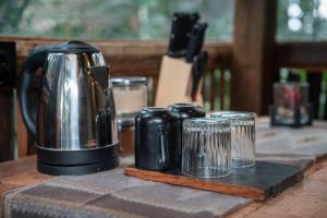 a coffee pot on a table with four cups at Folky House Sidemen in Silebeng