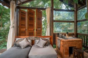 a bedroom in a tree house with a couch and a fireplace at Folky House Sidemen in Silebeng