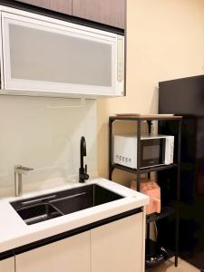 a kitchen with a sink and a microwave at 想睡覺民宿 in Hsia-ch'ing