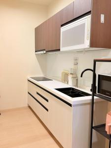 a kitchen with a sink and a microwave at 想睡覺民宿 in Hsia-ch'ing +54 photos