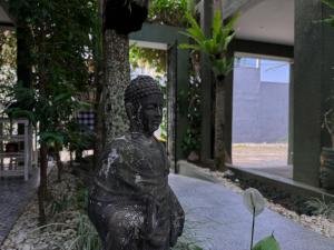 a statue of a woman sitting on a sidewalk at The Lodge Canggu in Tumbak Bayuh