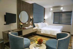 a hotel room with a bed and a table and chairs at Sri Suryas Hotel in Colombo