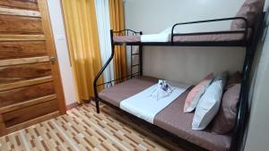 a bedroom with two bunk beds and a door at Victoria's Inn in Siquijor