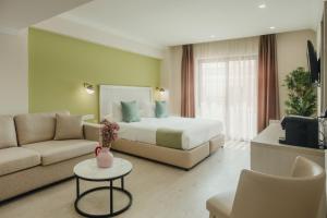 a hotel room with a bed and a couch at Roseum Boutique Hotel in Larnaca