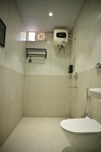 a bathroom with a shower and a toilet and a sink at Noi Homes - Entire 2BHK Luxury Flat with Parking, Kitchen and Balcony in Jorhat