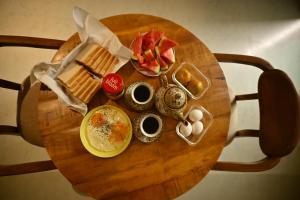 a round wooden table with breakfast foods on it at Noi Homes - Entire 2BHK Luxury Flat with Parking, Kitchen and Balcony in Jorhat +26 photos