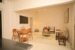 a living room with a table and chairs at Noi Homes - Entire 2BHK Luxury Flat with Parking, Kitchen and Balcony in Jorhat