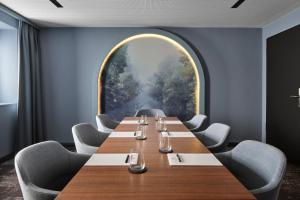 a conference room with a long table and a large window at Jakobsberg Nature Resort - Hotel & Golf in Boppard +50 photos