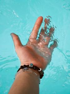 a person holding their hand up in the water at Prouds House in Ban Hua Phlong