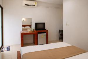 a bedroom with a bed and a television and a table at 169 Home Resort in Ban Huai Khram
