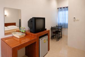 a living room with a television on a wooden table at 169 Home Resort in Ban Huai Khram