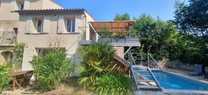a house with a swimming pool next to a building at La Pastorale in Nyons