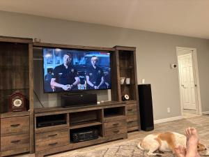 a dog laying on the floor in front of a television at 907 elm in Rodeo +2 photos