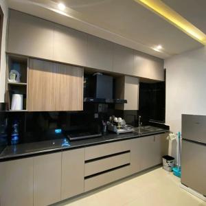 eine Küche mit weißen Schränken und schwarzen Arbeitsplatten in der Unterkunft Park Ridge Hotel Serviced Apartments - Executive Valley View Apartment in Murree
