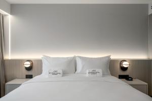 a large white bed with two pillows on it at Maison Hotel Bangkok in Bangkok +69 photos