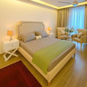 ein Schlafzimmer mit einem großen Bett und einer grünen Decke in der Unterkunft Park Ridge Hotel Serviced Apartments - Executive Valley View Apartment in Murree