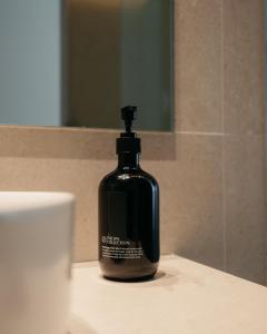 a bottle of mouthwash sitting on a bathroom sink at Hostal Serea in Denia