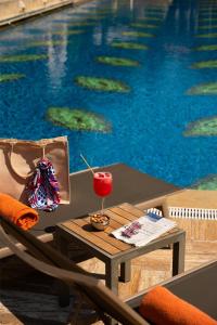 a table with a drink on it next to a swimming pool at Grand Hyatt Istanbul in Istanbul