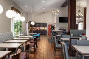 a restaurant with tables and chairs and a kitchen at Hampton Inn Morristown in Morristown
