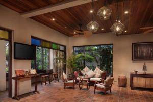 a living room with a couch and a tv at Maison Dalabua in Luang Prabang