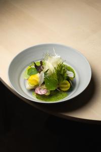 a white plate with a salad on a table at Casa Caminada in Fürstenaubruck