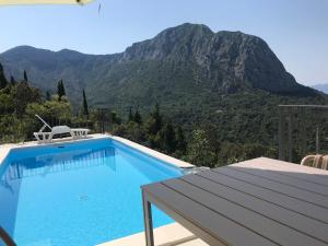 a swimming pool with a mountain in the background at HOLIDAY HOME m&n in Zaostrog