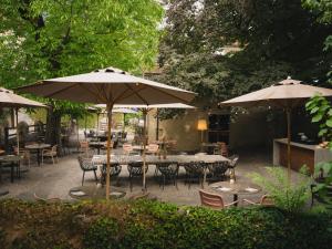 an outdoor patio with tables and chairs and umbrellas at Casa Caminada in Fürstenaubruck