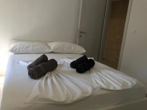 a white bed with two black towels on it at HOLIDAY HOME m&n in Zaostrog