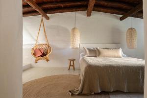 a bedroom with a bed and a hanging chair at Hotel Can Sastre in Santa Gertrudis de Fruitera +55 photos