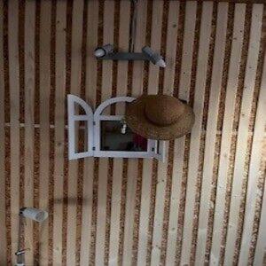 a hat on a wall with a small window at Ostrzycki Raj in Pierszczewo