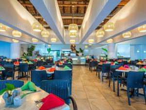 a dining room with tables and chairs and lights at Park Royal Beach Huatulco in Tangolunda