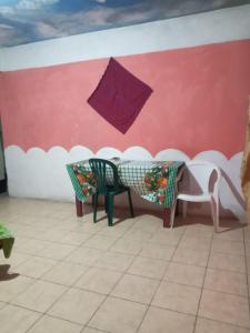 a room with a table and chairs and an umbrella at House the Cats in Panajachel