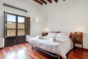 a bedroom with a bed with white sheets and a window at Can Vallori in Sencelles