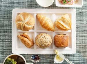a white tray with bread and croissants and other foods at Super Hotel Kushiro Kurogane in Kushiro