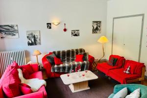 a living room with red couches and a table at Magnificent duplex in a former Palace in Chamonix