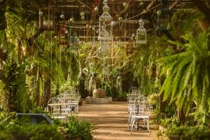 a garden with white chairs and plants and lights at Maison Dalabua in Luang Prabang
