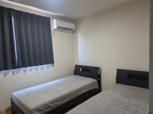 a small room with two beds and a window at アパートメントホテル憩 in Yanagawa